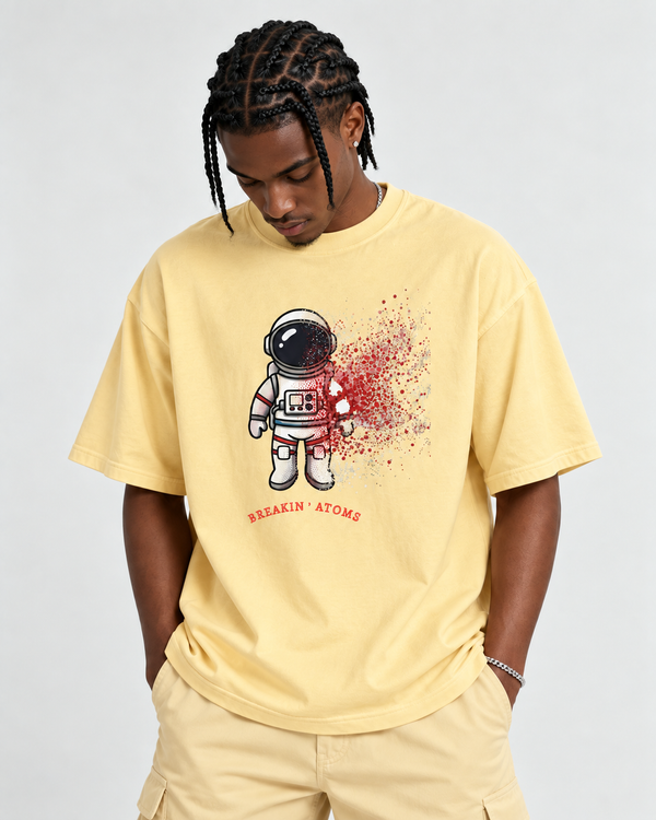 Black male model wearing Breakin’ Atoms Into Another World graphic tee in Butter with matching pants