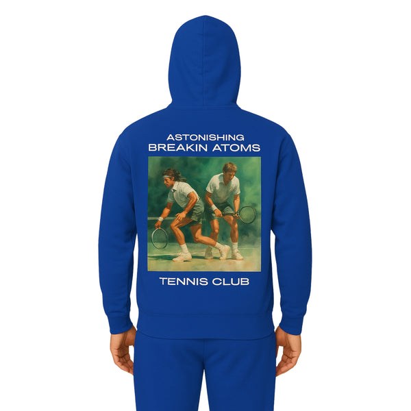 Model wearing the Astonishing Breakin’ Atoms "Tennis Club Sweater" — a classic crewneck with varsity-style lettering and retro tennis club branding, merging preppy sportswear with bold cultural streetwear.