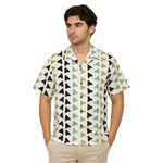 Model wearing Breakin' Atoms "Arrowhead Unity" short-sleeve button-up shirt with retro geometric arrowhead print in black, olive, and teal. thumbnail 1