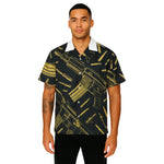 Model wearing Breakin' Atoms "Golden Arsenal Vacation Shirt," a short-sleeve button-up featuring a bold gold and black pattern inspired by power, strength, and luxury — perfect for resort wear or elevated summer outfits. thumbnail 1