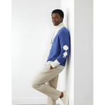 “Breakin’ Atoms L Cloud Thread Cardigan in blue with cream ribbed collar, cuffs, and hem, button-front knit cardigan featuring a white sleeve logo graphic, shown on model in side profile.” thumbnail 1