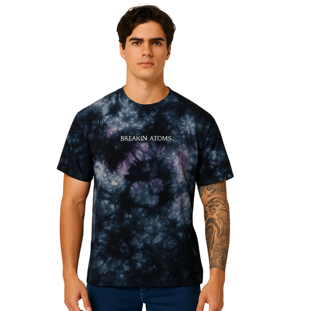 Male model wearing Breakin' Atoms Marble Logo Tee in black and purple tie-dye with centered logo text — Breakin Atoms premium streetwear