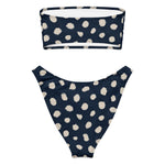 Model wearing the Dotti bikini set, front view, featuring navy ink-drop pattern bandeau top and high-cut V bikini bottom. thumbnail 2